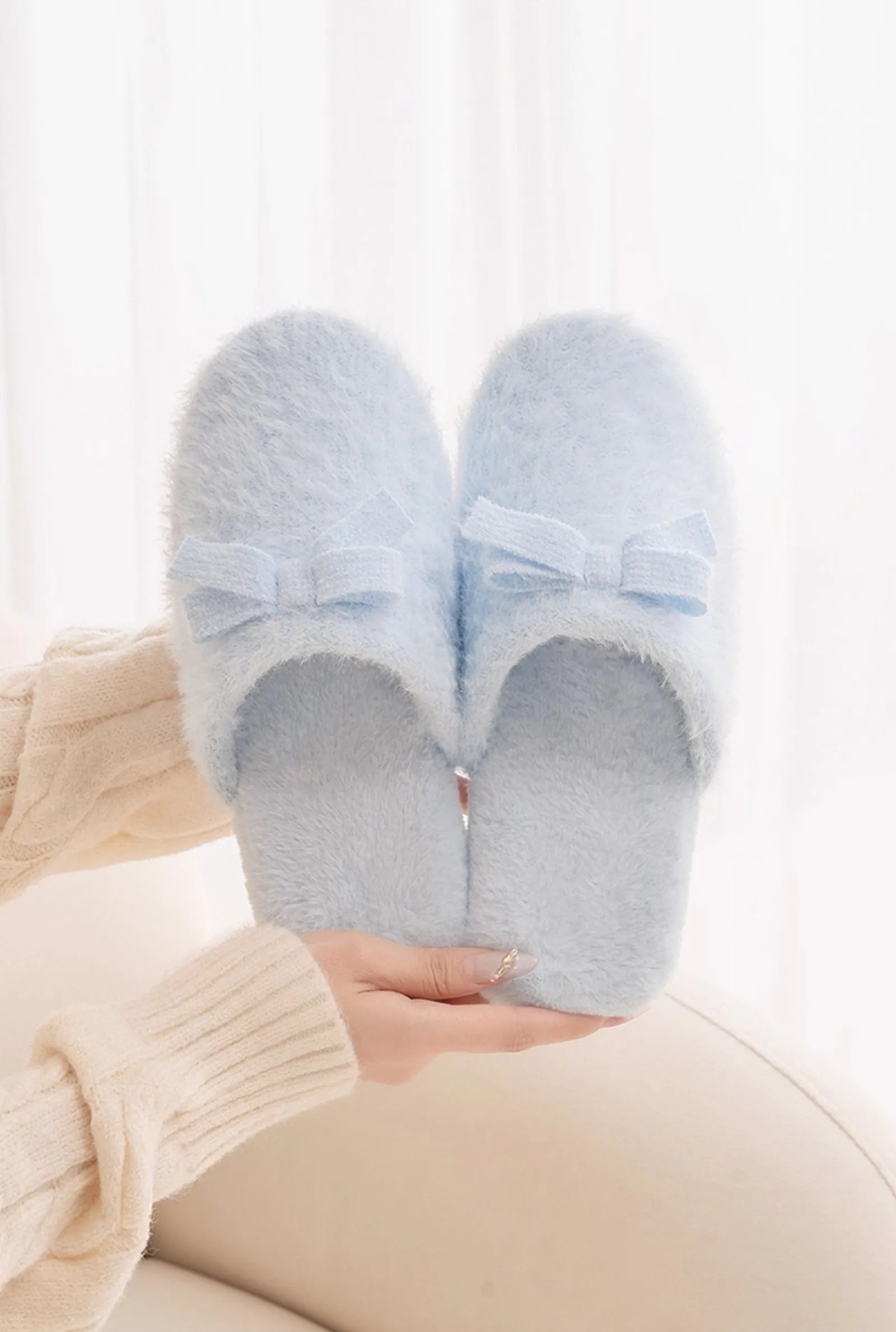 Close Up of Blue Plush Slippers Held in Hands showing Texture - RoomDen