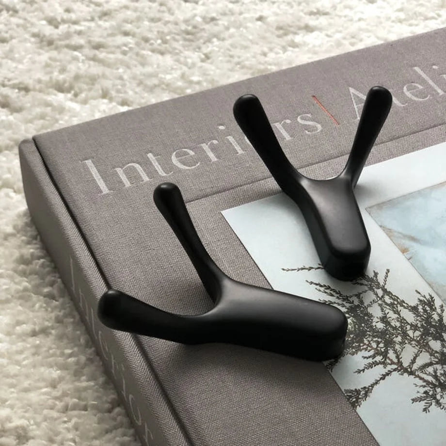 Variant Product shot: Another angle of the two black metal hooks on a book, on a plush white rug - RoomDen