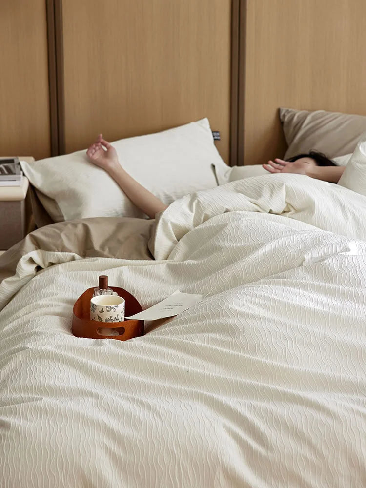 A person sleeping in the Cream White & Beige Wavy Textured bedding, showing the soft fabric. - RoomDen
