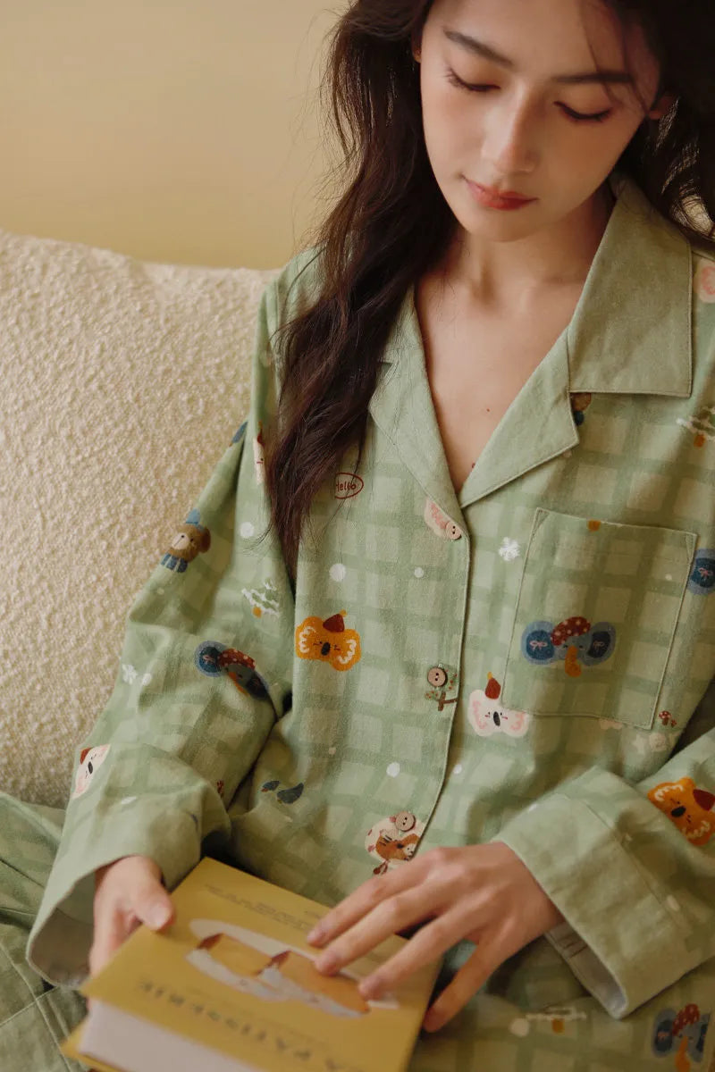 Close-up detail of koala and bear illustrations on green plaid washed cotton pajama top