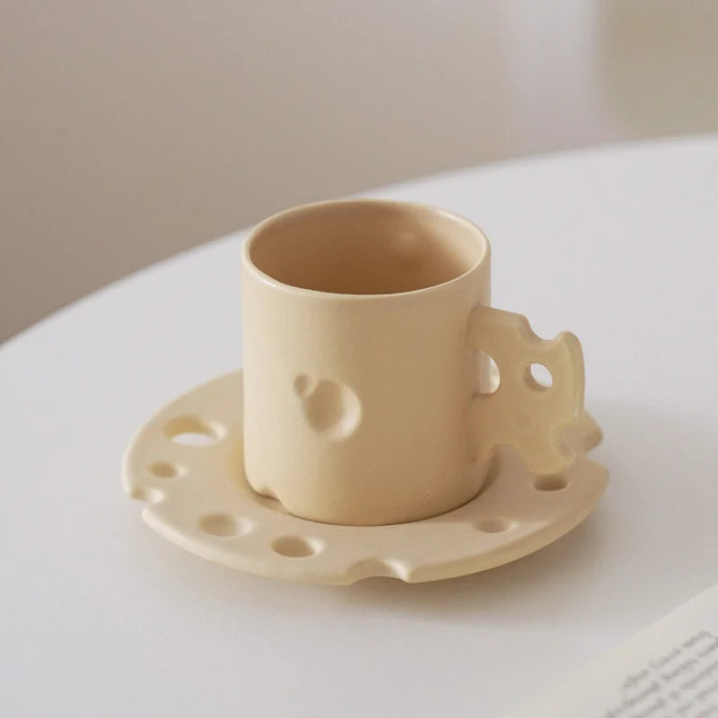 Side profile of the Cheese Yellow Ceramic Mug and Saucer, highlighting the cheese-like indentations. - RoomDen