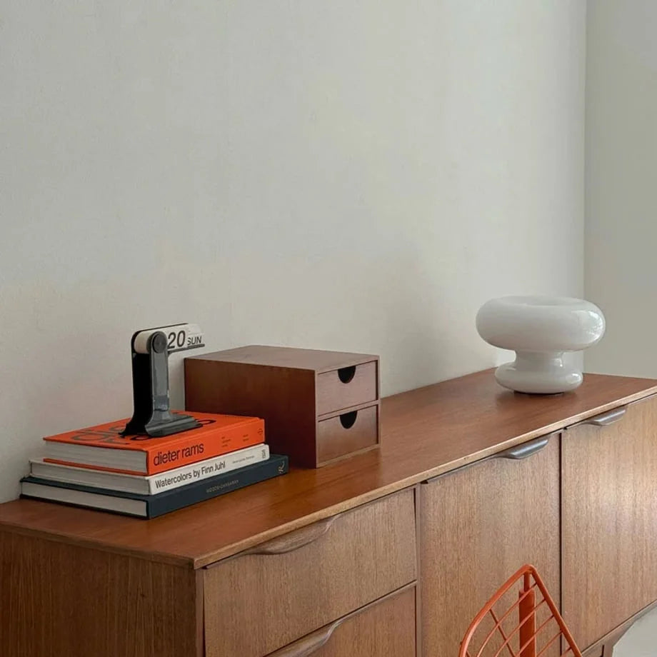 A wider view of the wooden desktop organizer on a credenza, with a mushroom lamp and modern orange chair nearby. - RoomDen