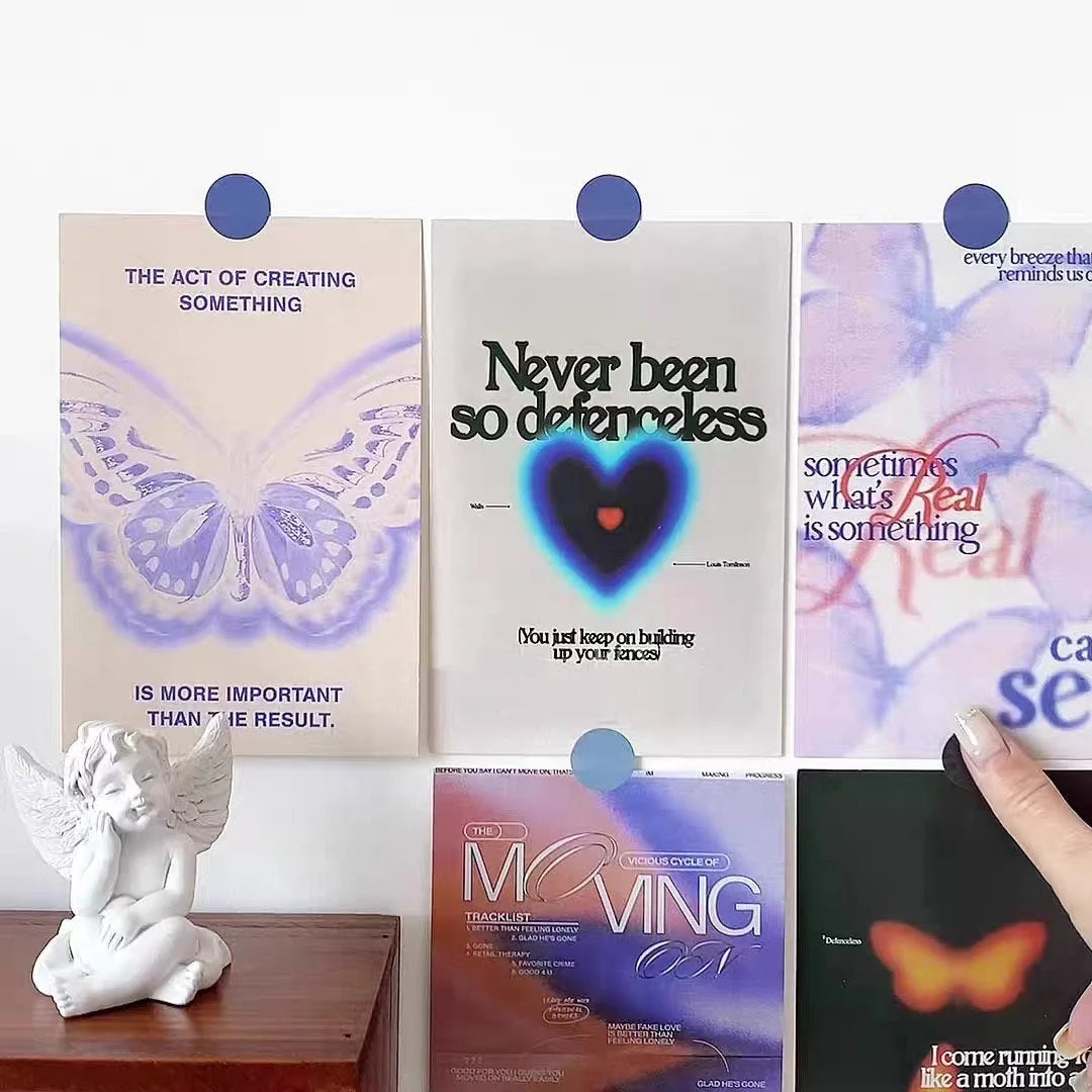 A collection of Y2K-inspired collage posters on a wall next to a small angel statue. - RoomDen