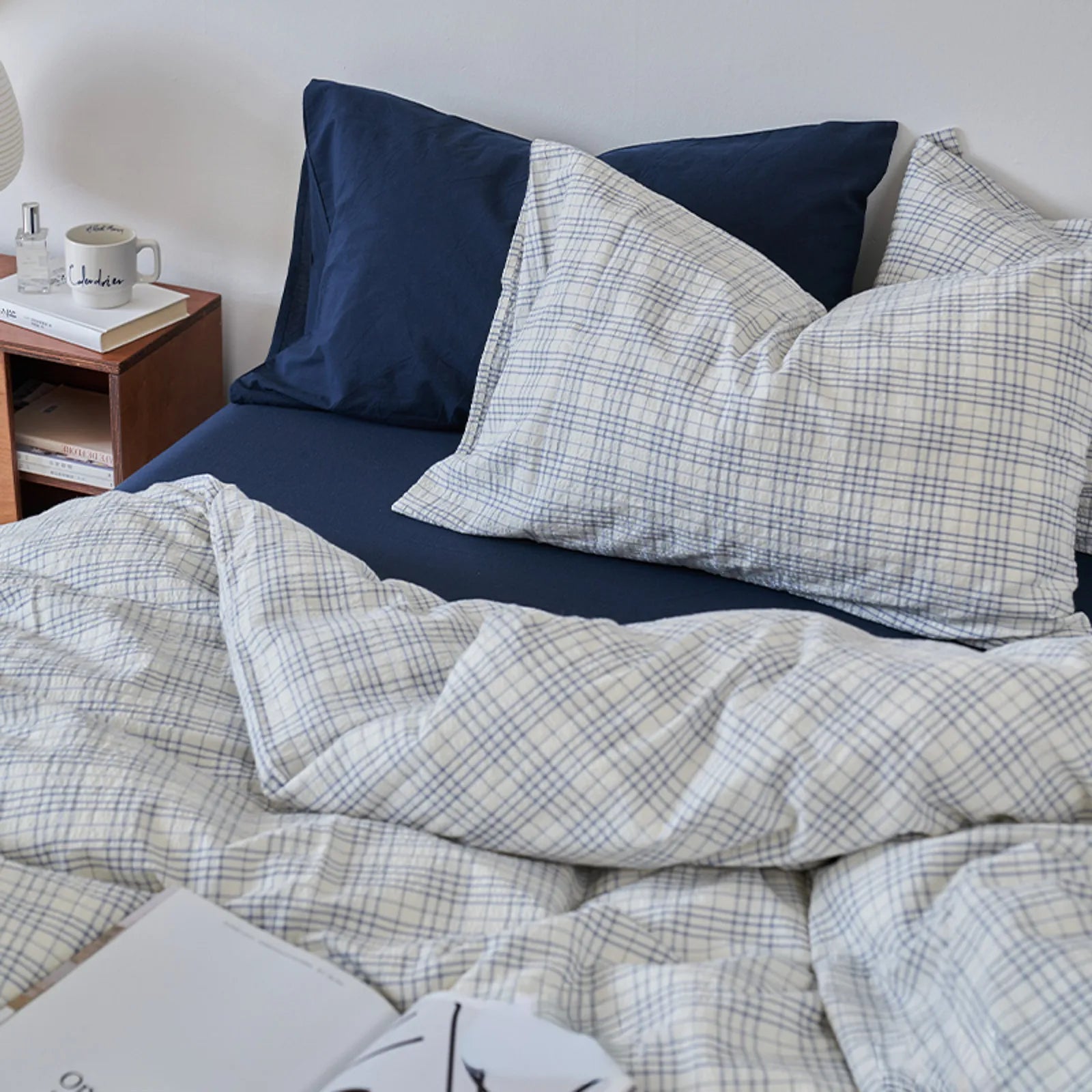 Close-up of Textured Plaid Washed Cotton Bedding Set in Navy Plaid on a bed with a wooden nightstand - RoomDen