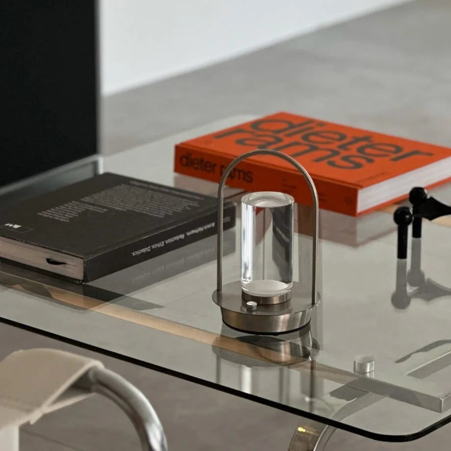 Close-up of the Minimalist Arch Metal Portable Table Lamp on a glass coffee table. - RoomDen
