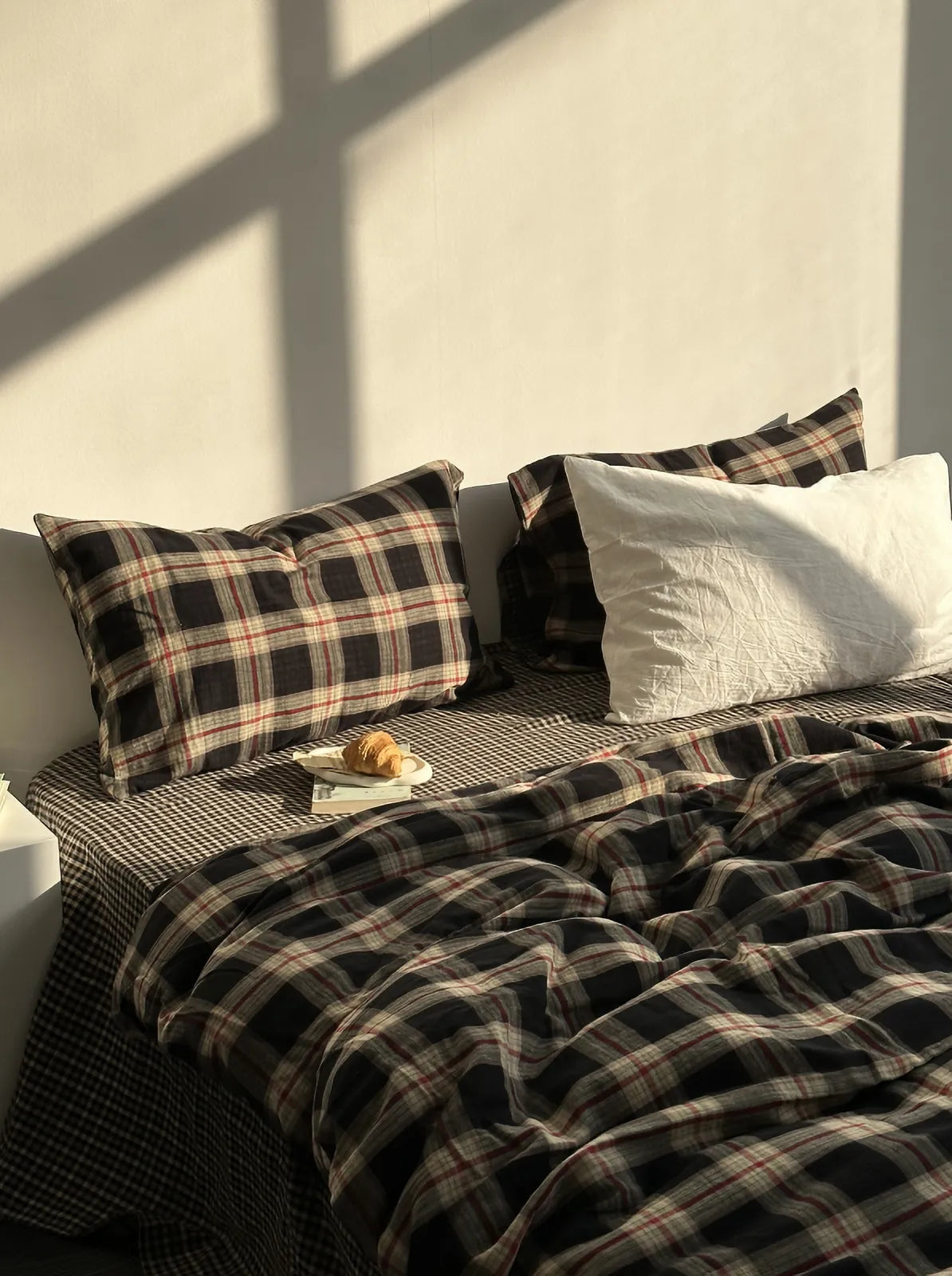 Textured Tartan Plaid & Gingham Washed Cotton Bedding Set on a bed with warm sunlight casting shadows on the wall - RoomDen.