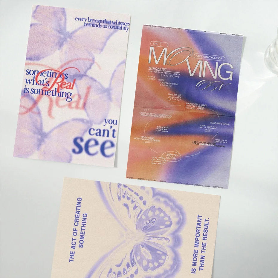 Three posters from the wall collage kit laid out on a white surface, featuring butterfly and typography designs. - RoomDen