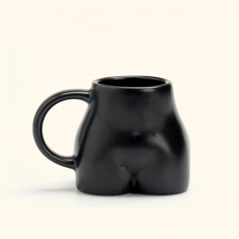 The black sculptural body ceramic mug with a matte finish on a white background. - RoomDen