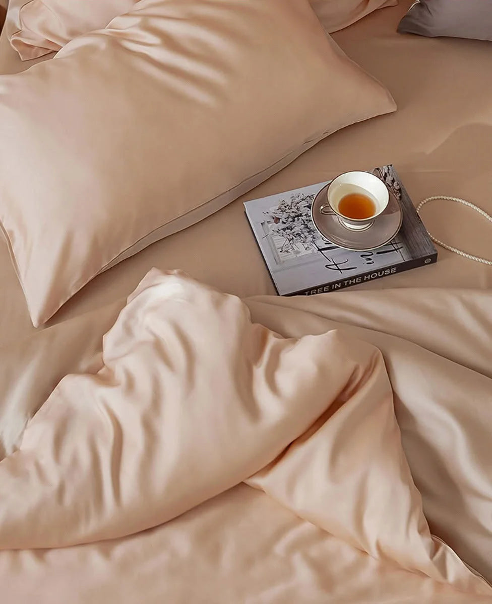 Overhead view of the lustrous Blush Pearl Cooling Tencel duvet cover and pillows. - RoomDen