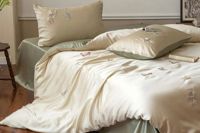 The Butterfly Embroidered Tencel Bedding Set styled on a bed, highlighting the smooth drape of the fabric - RoomDen