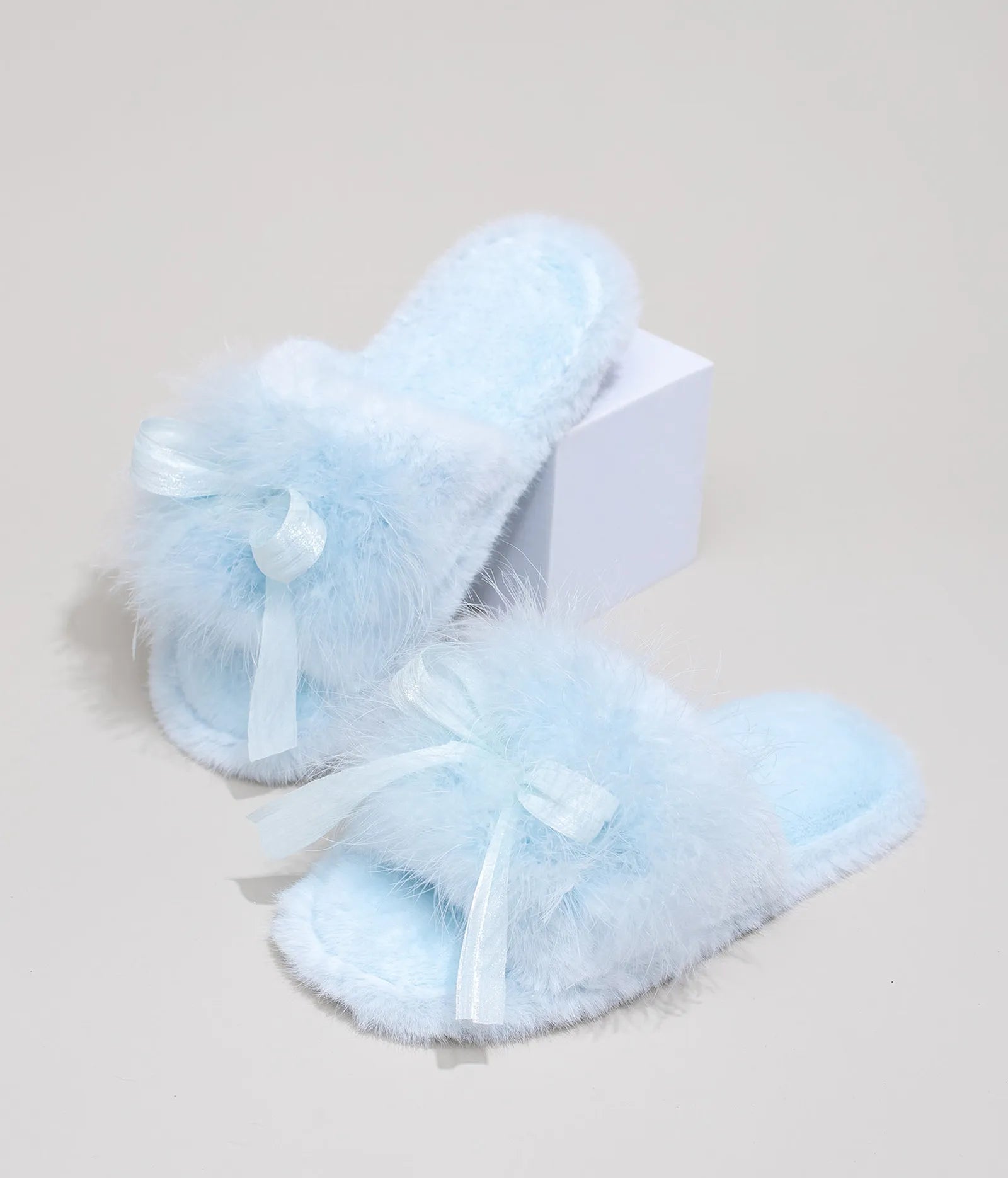 Baby Blue faux fur slide slippers with ribbon bow displayed on white box - RoomDen