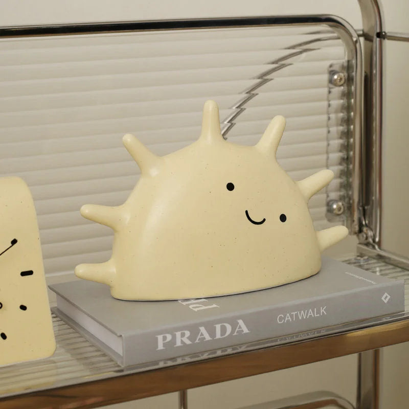 Creamy Beige Smiling Sun Jewelry Organizer styled on a PRADA book on a fluted glass shelf - RoomDen