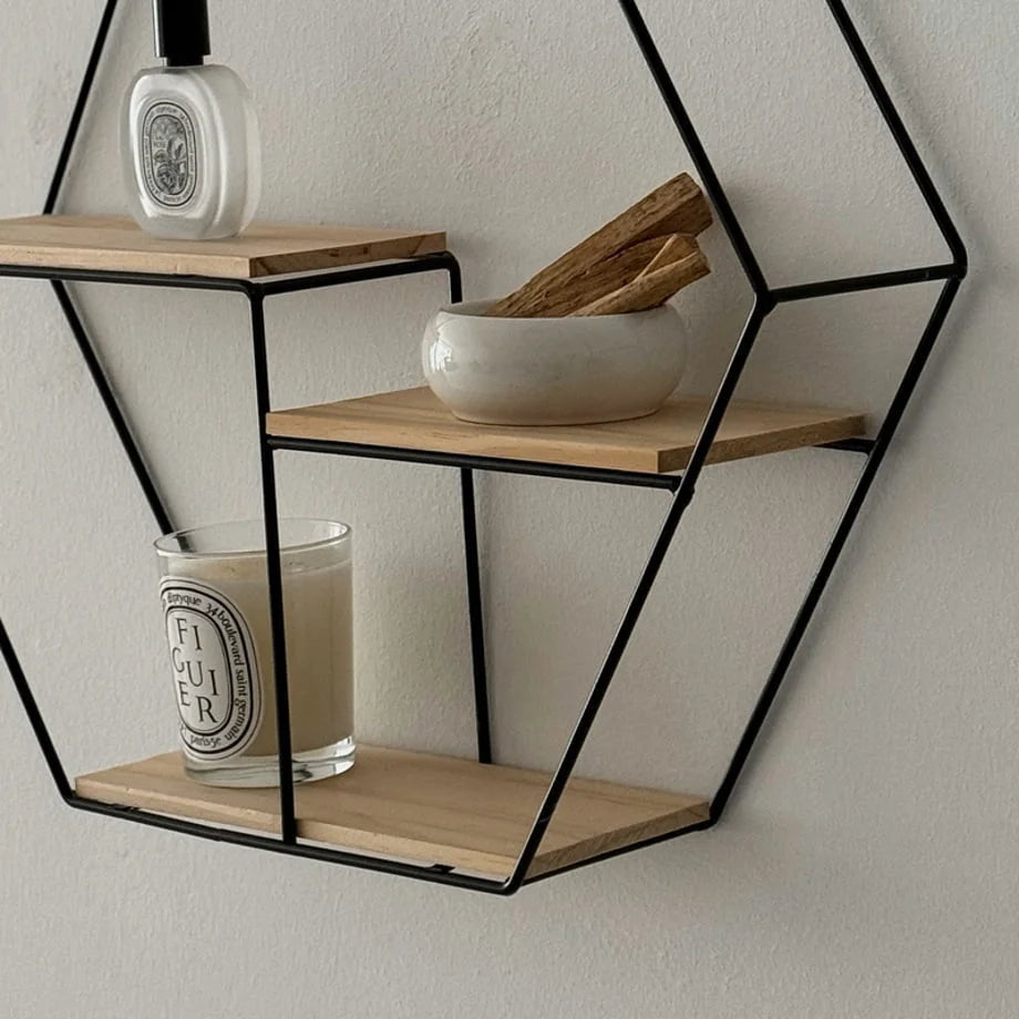 Detailed view of the items displayed on the Black Hexagon Wall Shelf's wooden tiers - RoomDen