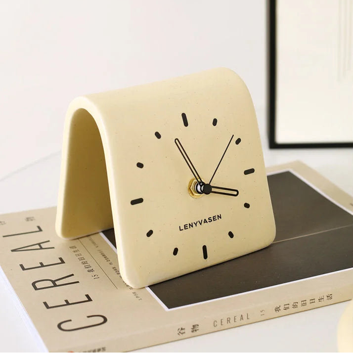 Duplicate lifestyle image of the Butter Yellow Matte Arch Ceramic Table Clock on a CEREAL magazine - RoomDen