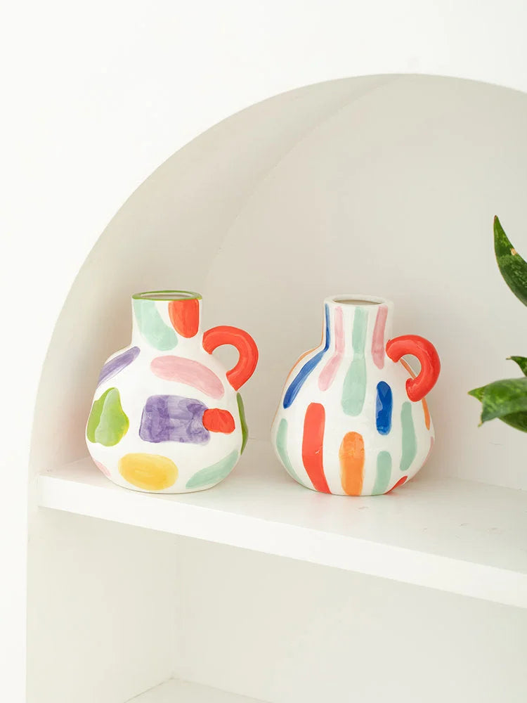 The single-handle spotty and striped ceramic vases displayed together on a white shelf. - RoomDen