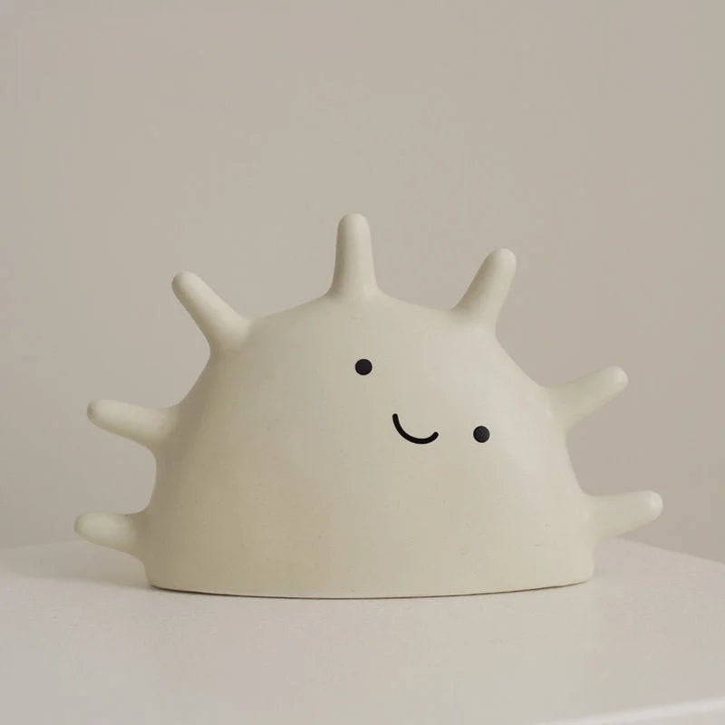 Front view of the Off-White Matte Ceramic Smiling Sun Jewelry Organizer on a white surface - RoomDen