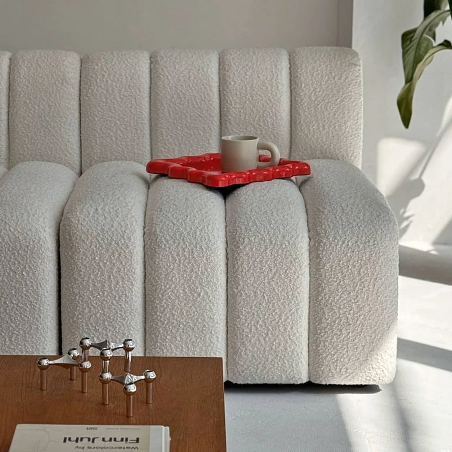 Cherry Red wavy tray styled with a mug on a white bouclé sofa, adding a pop of color - RoomDen