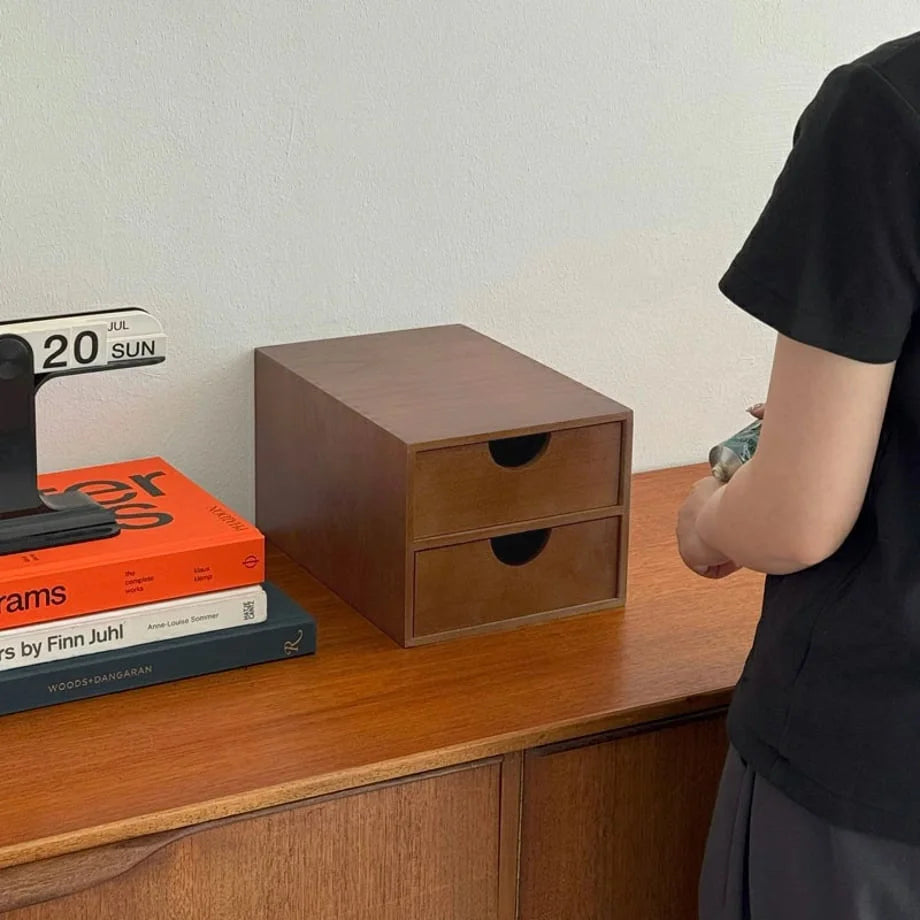 A person standing next to the two-drawer wooden organizer on a desk, demonstrating its scale. - RoomDen