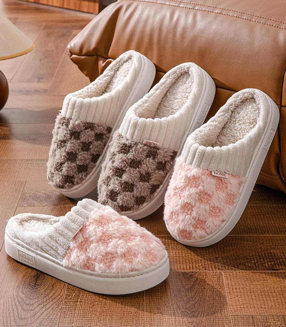 Fuzzy checkered house slippers in pink and brown on wooden floor - RoomDen