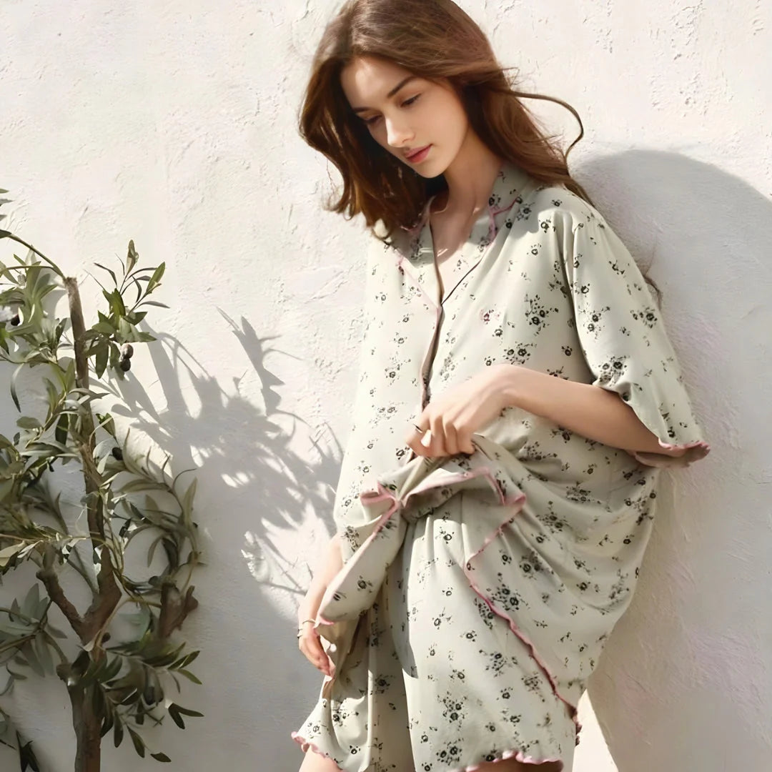 Model touching the soft Modal fabric of her floral pajama top, highlighting its texture. - RoomDen