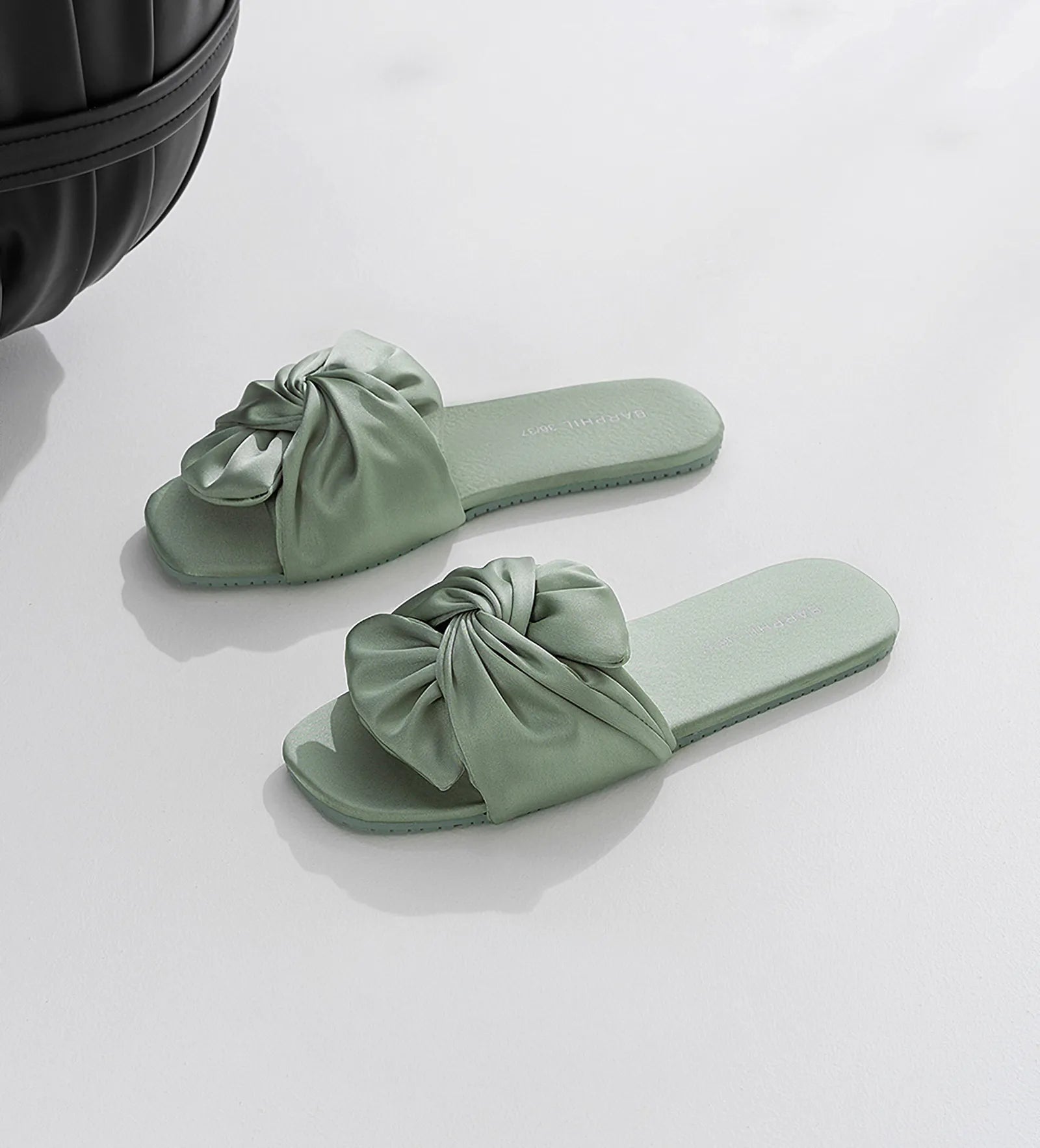 Pair of Sage Green Cotton Sateen Bow Slippers on white surface - RoomDen