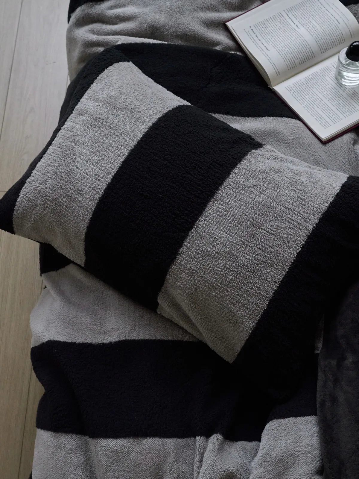 Detailed top-down shot of the textured black and grey striped flannel fleece pillowcase, showing the soft material. - RoomDen