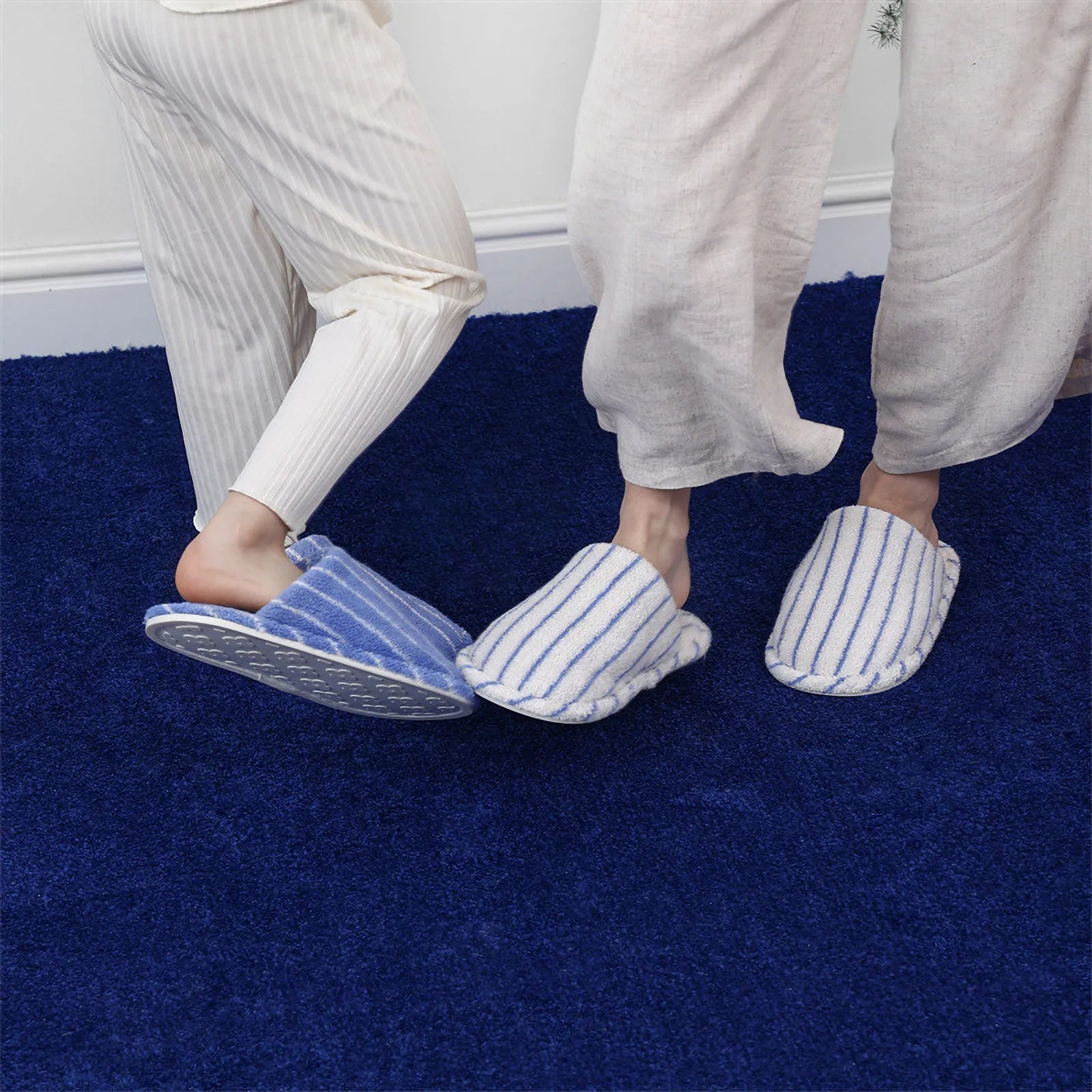 Two people standing wearing matching Blue and White Striped slippers