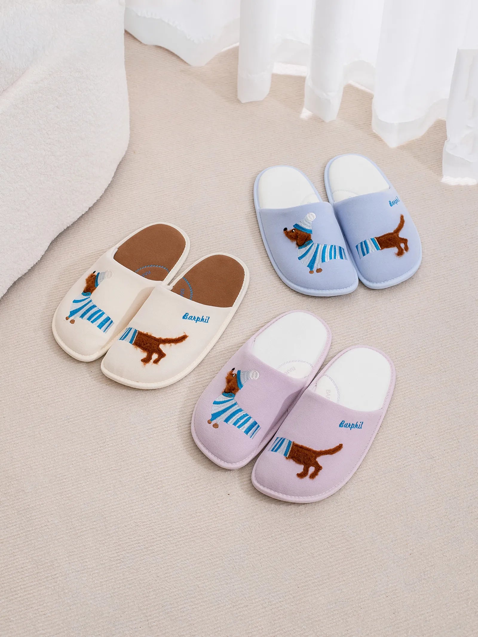 Comparison of white and baby blue dachshund slippers showing color variations and embroidery details