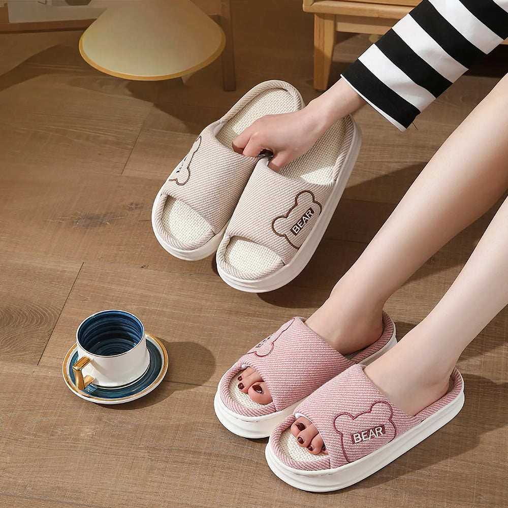 RoomDen Breathable Woven Embroidered Bear Linen House Slippers in Beige and Pink held in hand