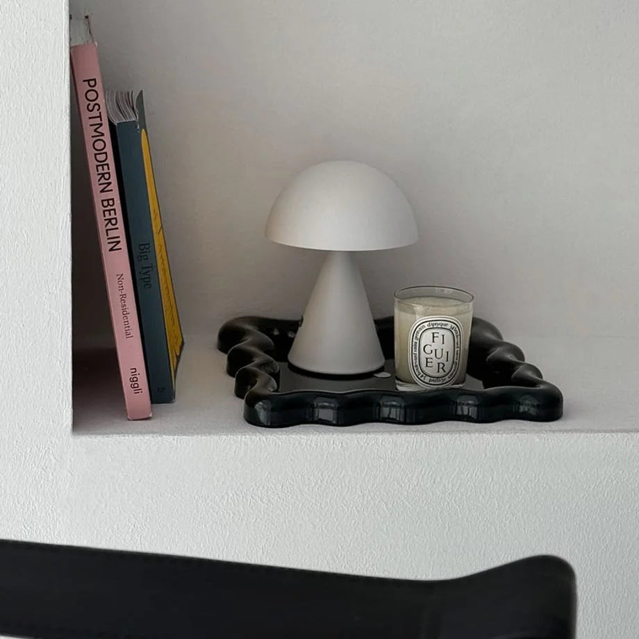 Glossy Black wavy tray on a white built-in shelf with a candle and lamp - RoomDen