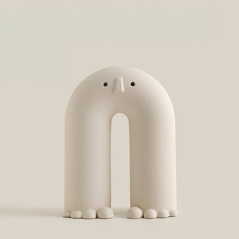 A studio shot of the white Arch Frosted Minimalist Face Vase against a light beige background. - RoomDen