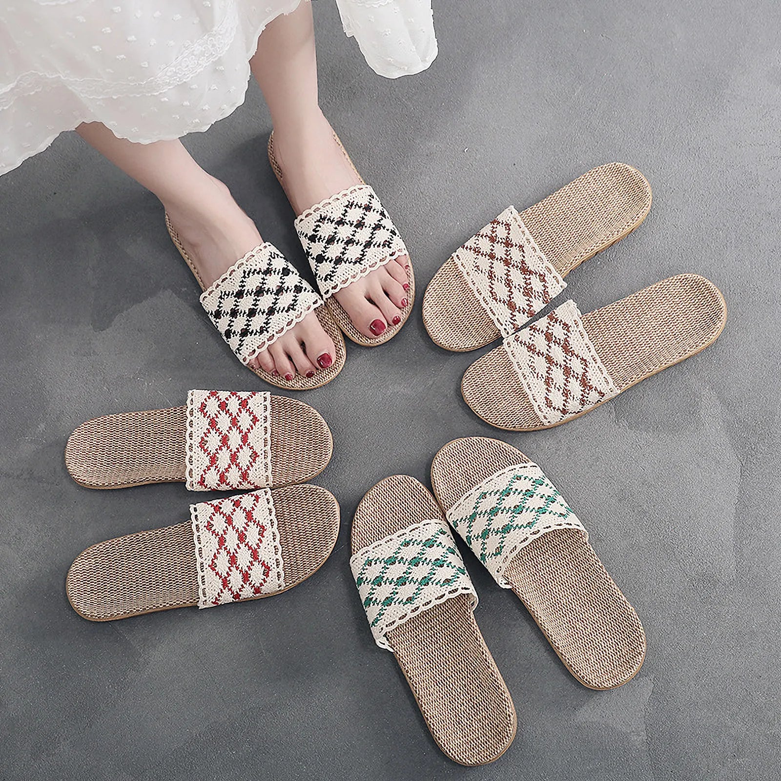 Circle arrangement of beige brown and camel woven house slippers on grey floor