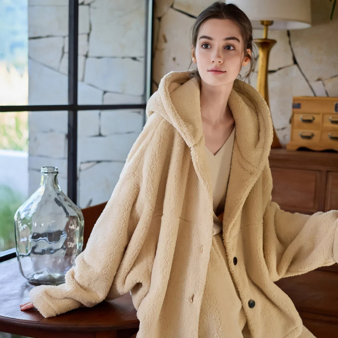 Model sitting at a wooden table wearing a cozy beige flannel fleece pajama set. - RoomDen