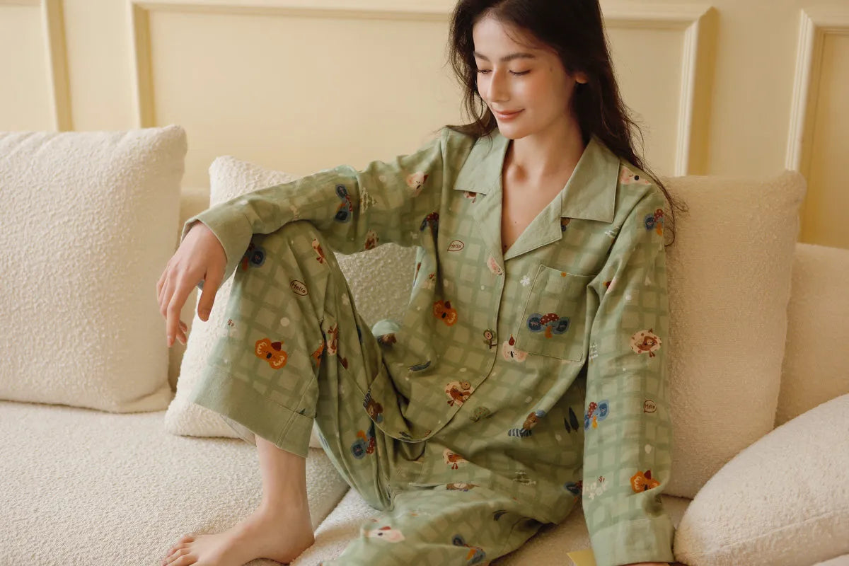 Woman relaxing on sofa in sage green animal print pajama set looking down