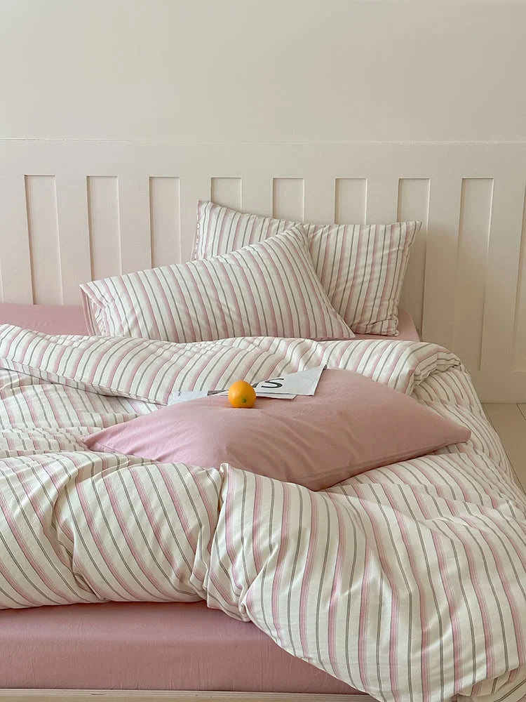 Close-up of the Pink Striped variant of the Textured Pinstripe Washed Cotton Bedding Set on a pink sheet. - RoomDen