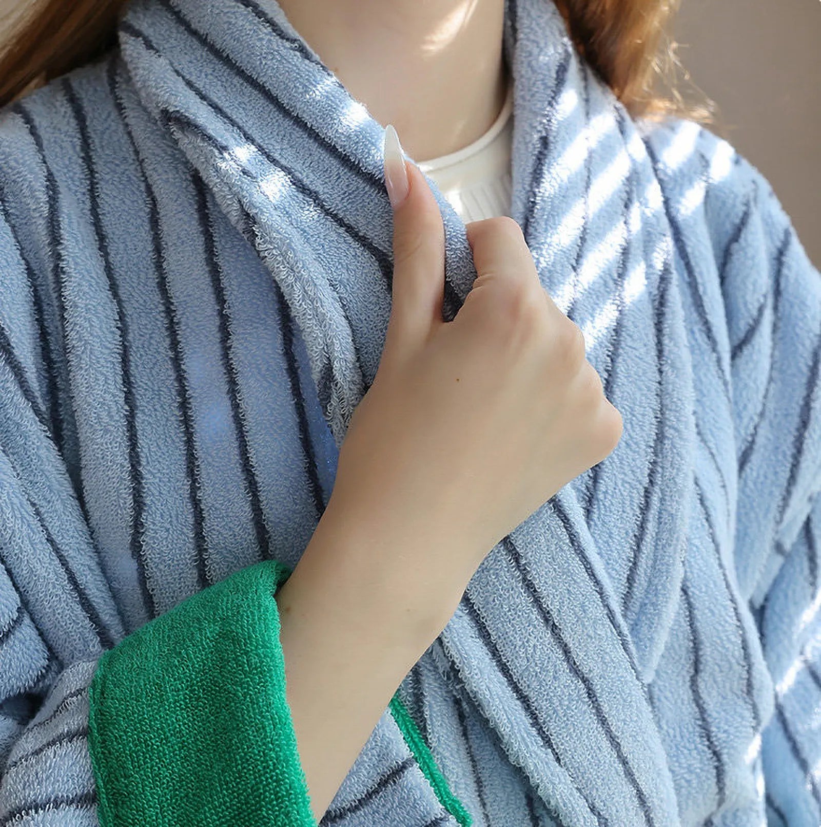 Close-up detail of the plush terry cloth texture and blue stripes on the robe collar.