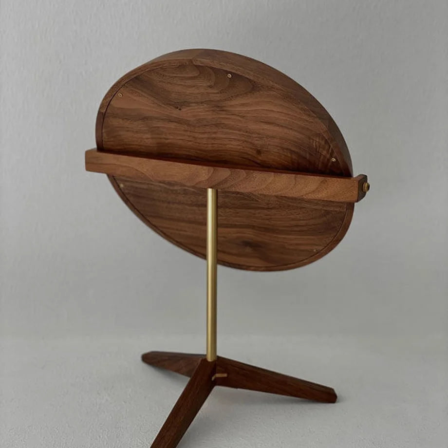 Back view of the round desktop mirror, displaying the rich grain of the solid walnut wood.