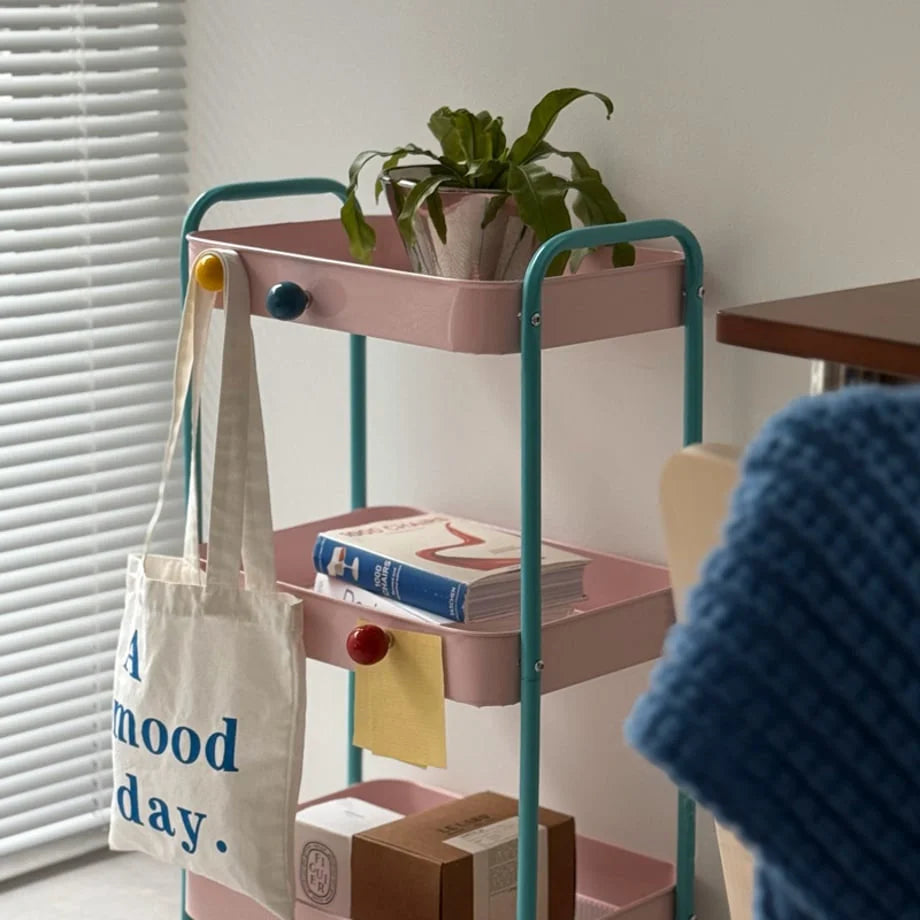 Yellow, blue, and red magnetic hooks on a pink metal rolling cart holding a tote bag. - RoomDen