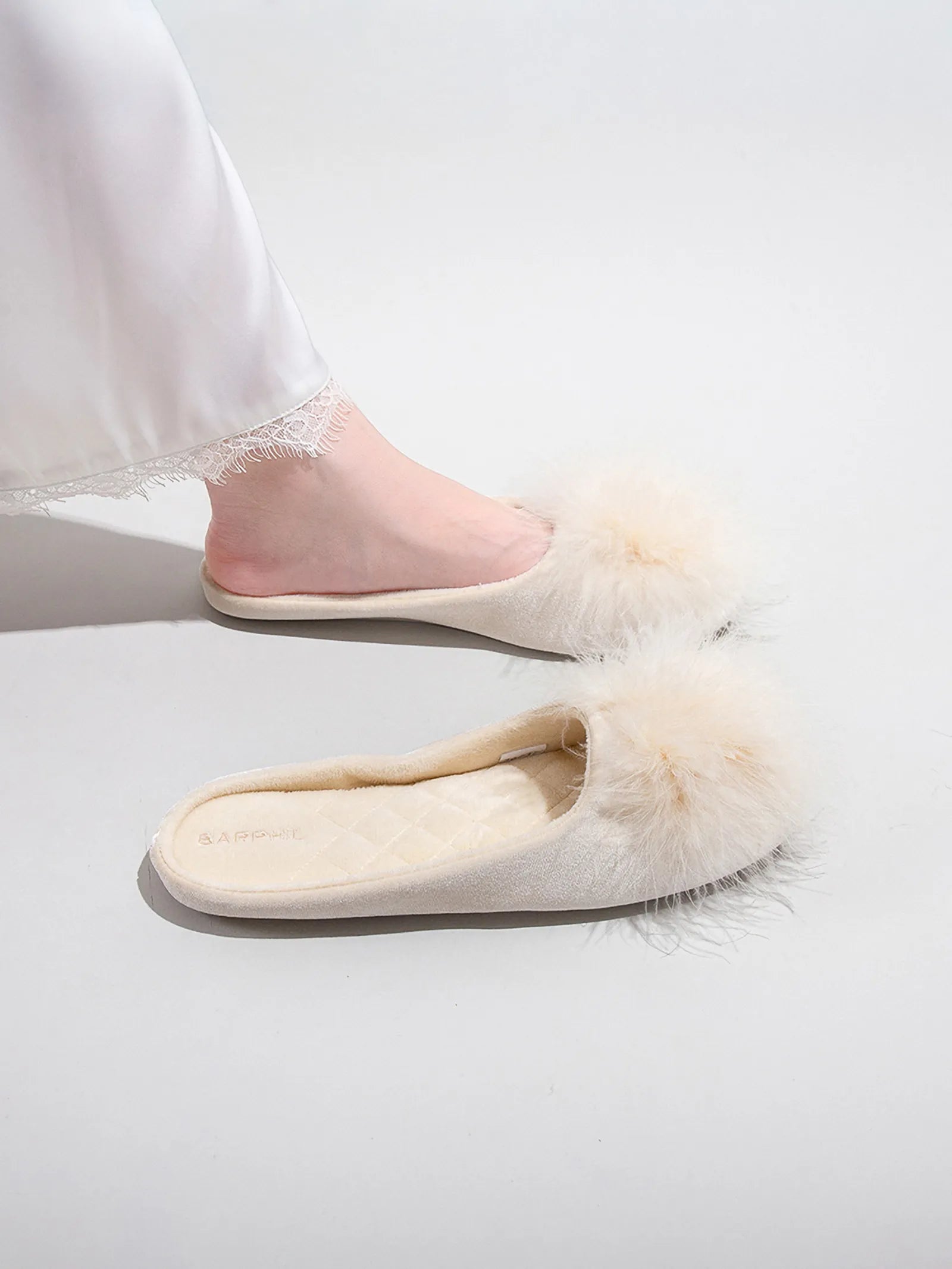 Side profile detail of beige plush slipper on foot - RoomDen