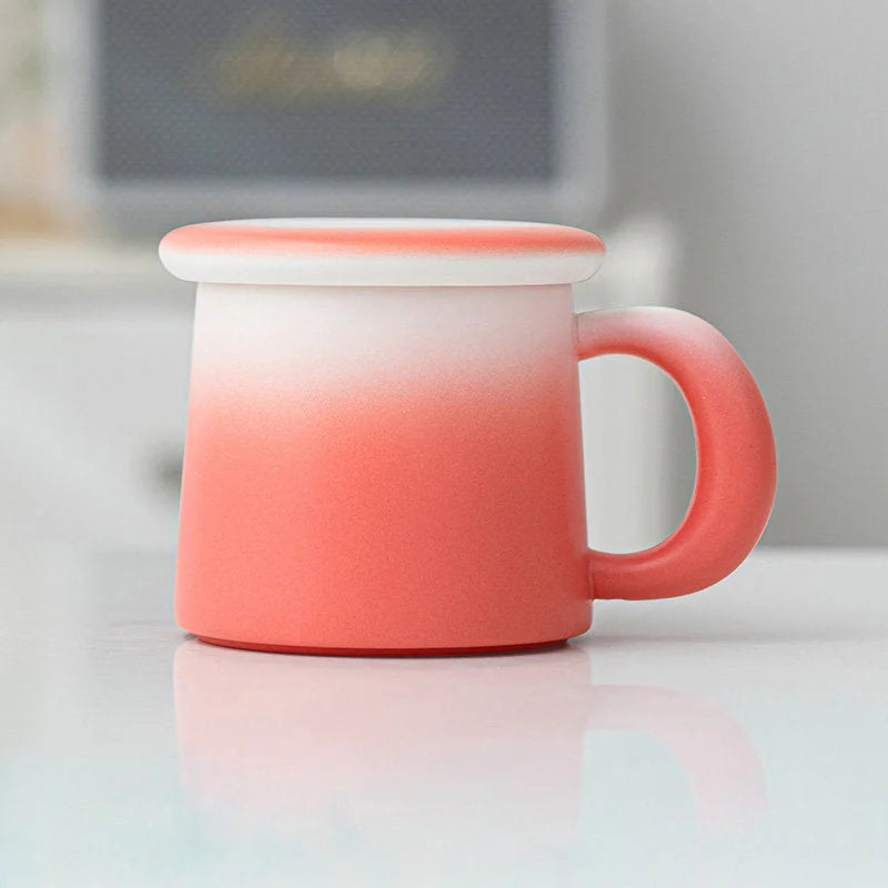 Side view of the Coral Ombre Frosted Ceramic Mug with lid on a white surface - RoomDen.