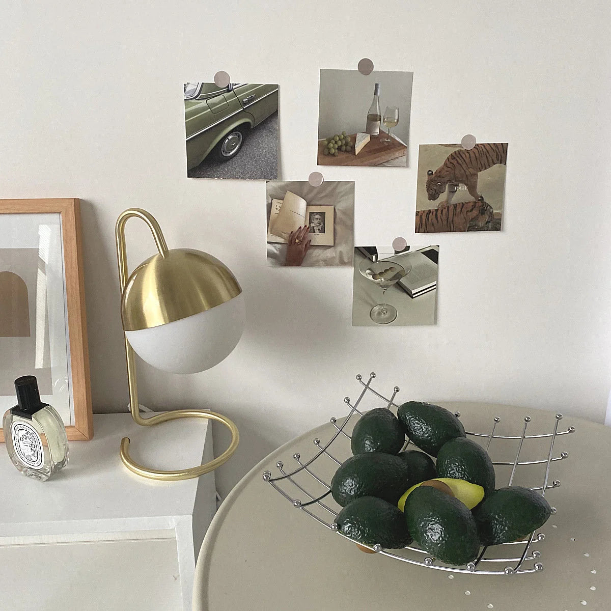 Aesthetic Wall Collage Kit adding a sophisticated vibe to a modern desk with a gold lamp and avocados - RoomDen