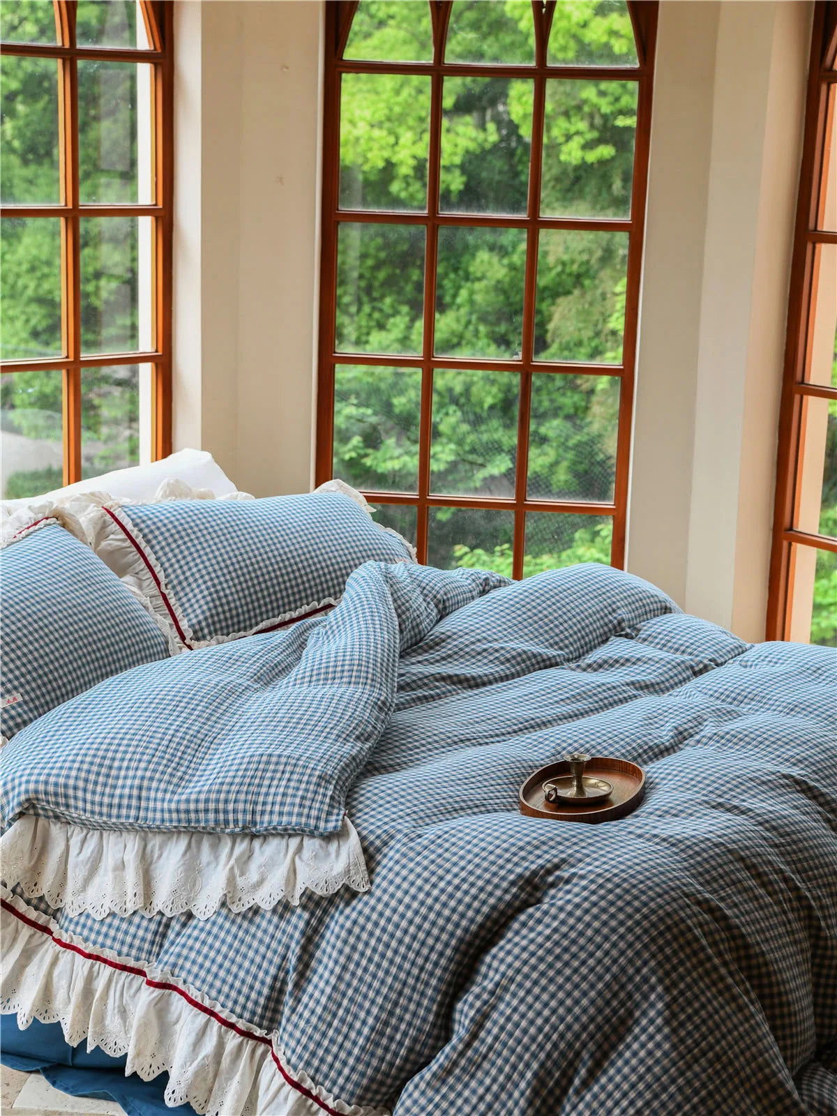 A cozy shot of the Blue Gingham duvet cover and pillows, with a wooden tray on top. - RoomDen