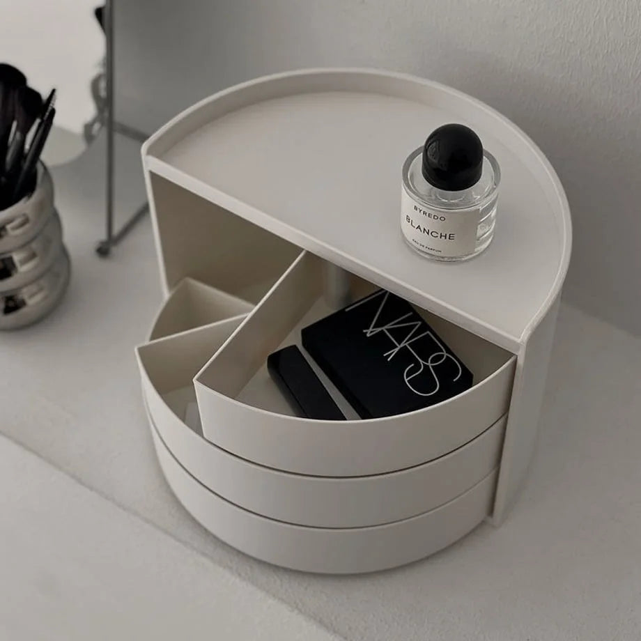 Top-down view of the rotating makeup organizer with drawers open, showing NARS and Chanel products inside. - RoomDen