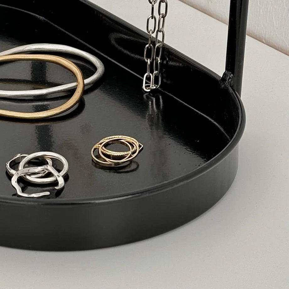 Detail shot of rings in the black tray of the Arched Metal Jewelry Organizer. - RoomDen