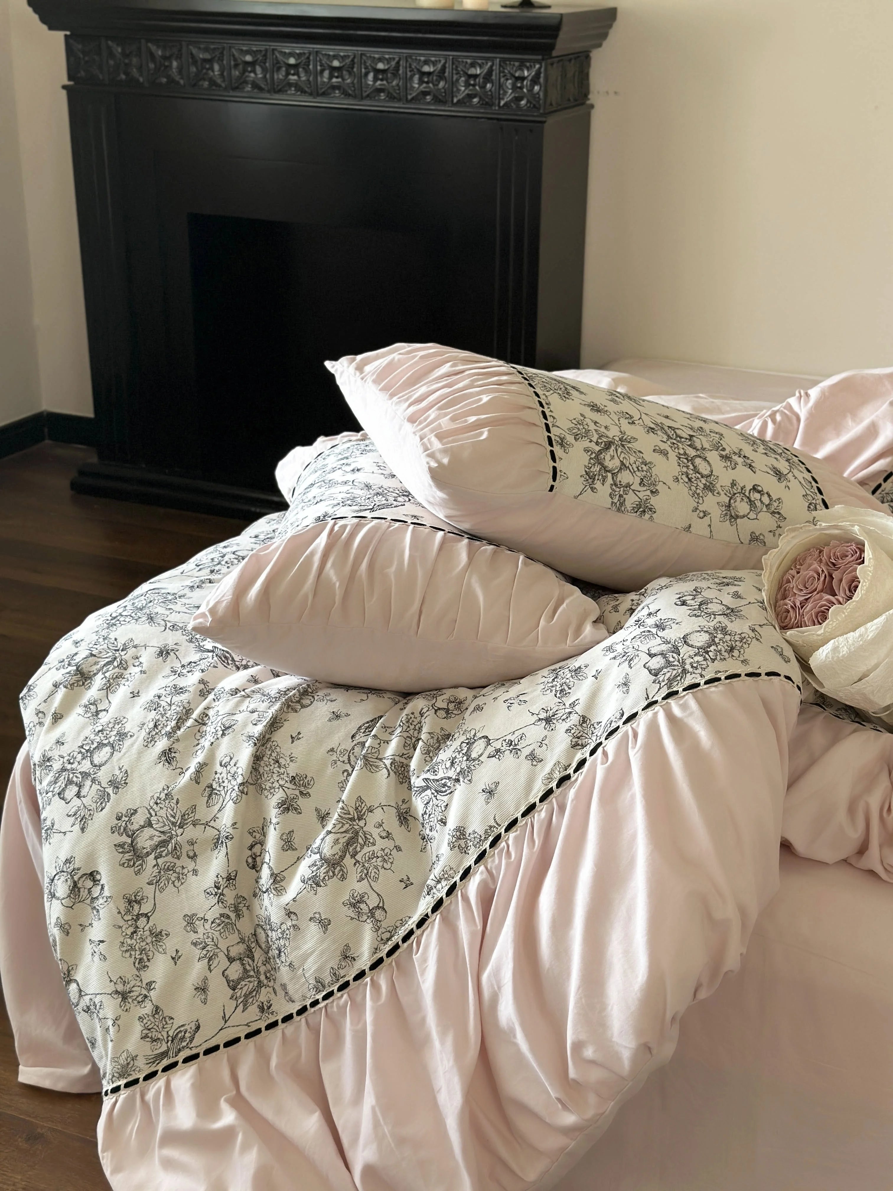 Another angle of the Pink Toile bedding set, showing the contrast with the dark floor and fireplace. - RoomDen