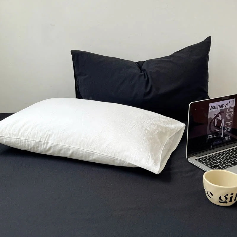 Detail of White Cotton Pillowcase against Black Sheet