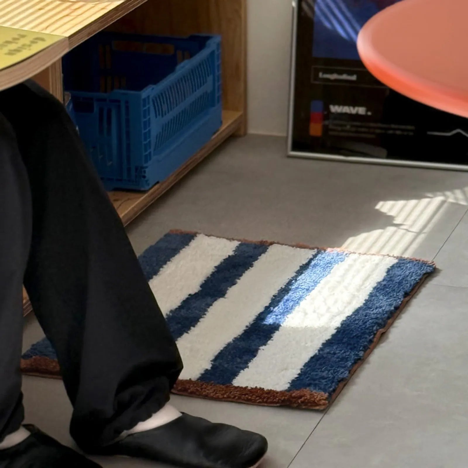 Plush striped rug placed near desk legs on floor - RoomDen