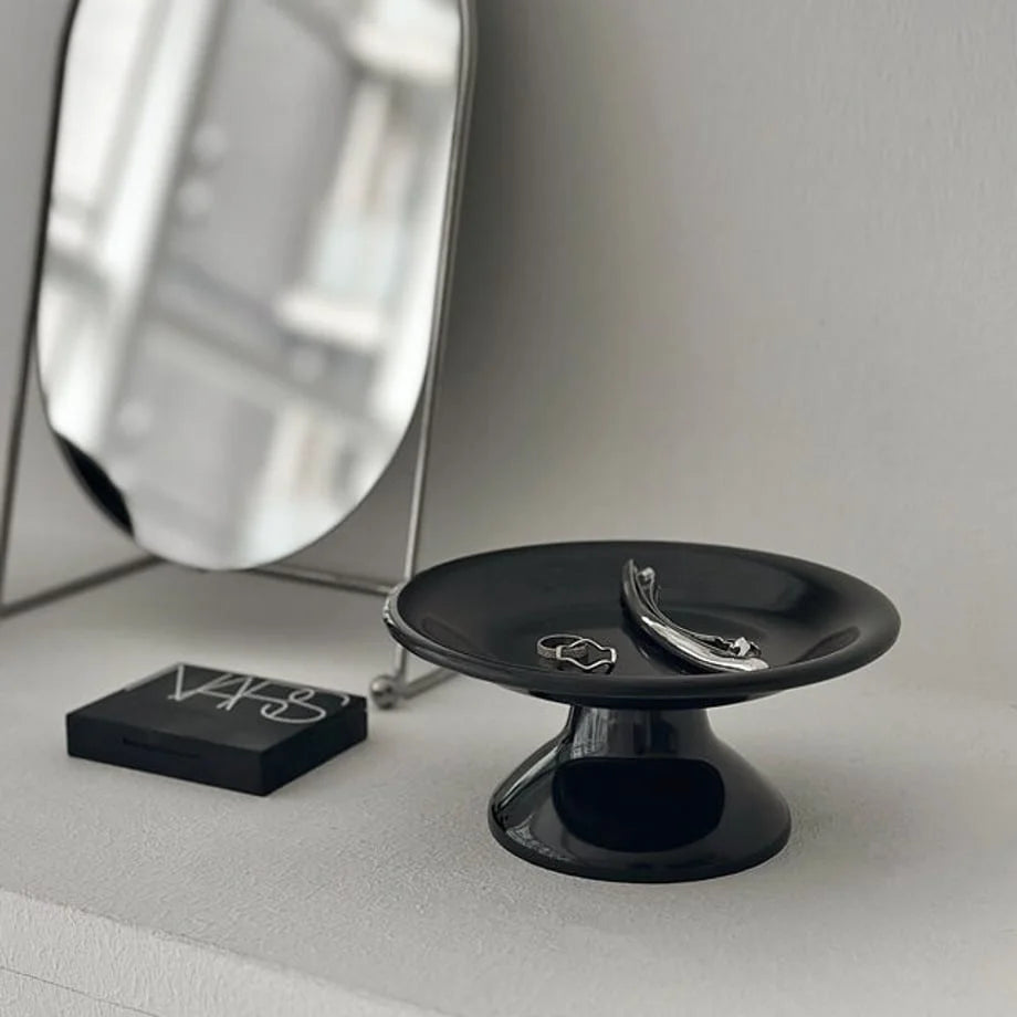A focused shot of the black pedestal jewelry organizer displaying silver rings and a clip. - RoomDen