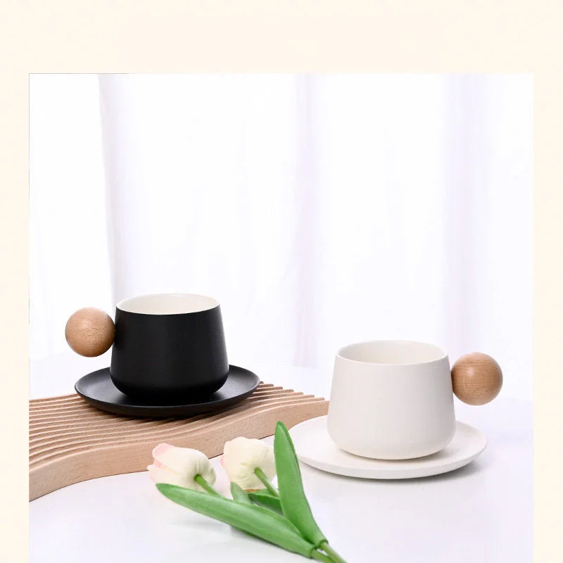 A Frosted Ceramic Mug Set in Black and another in Creamy White, displayed on a wooden tray with tulips. - RoomDen
