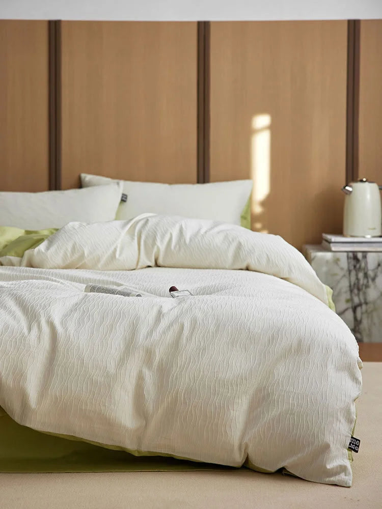 Side view showing the Cream White & Matcha Green Wavy Textured duvet cover on a bed. - RoomDen